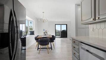 Una cocina moderna con comedor, ventanas amplias y vistas al exterior.