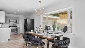 A modern kitchen with a dining area, featuring a large window, a chandelier, and a view of the outside. - 5bed/3ba, Gameroom, Pool, Spa, Sleeps 20+, Views (San Diego)