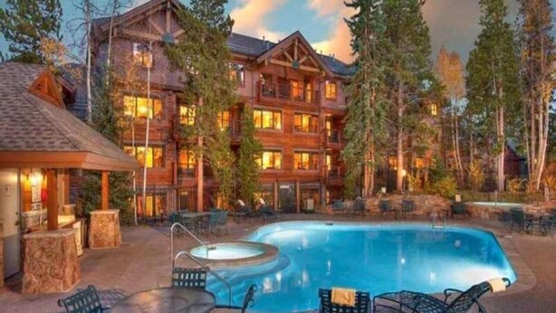 A lodge with a pool, outdoor seating, and a large building with multiple windows. - Mountain Thunder Lodge 2 Bedroom Condo - Ski In via Skyway Skiway! (Breckenridge)