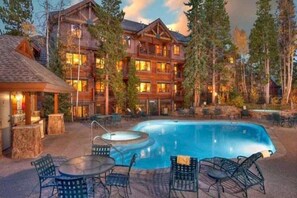 A lodge with a pool, outdoor seating, and a large building with multiple windows. - Mountain Thunder Lodge 2 Bedroom Condo - Ski In via Skyway Skiway! (Breckenridge)