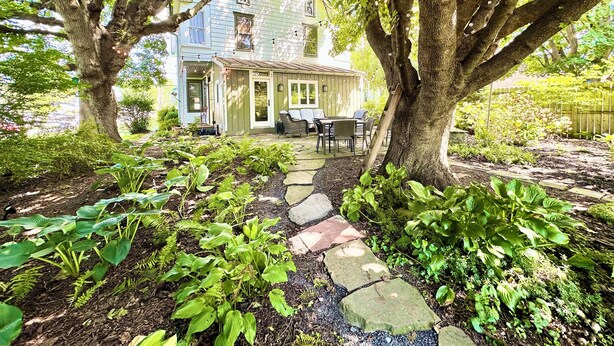 A house with a stone pathway leading to a porch, surrounded by lush greenery and trees. - 2,200 Sq Ft w/ 2 Gamerooms, Firepit & Grill 15 Minutes To Hershey (Palmyra)