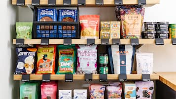 A variety of snack and food products displayed on shelves in a store.