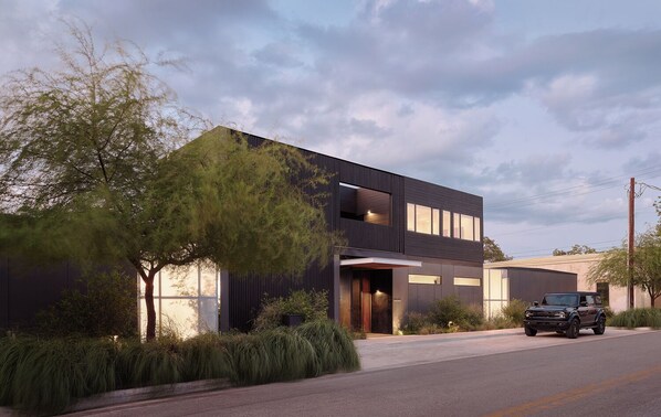 A modern two-story building with a flat roof and large windows.