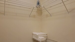 A corner laundry area with a ceiling-mounted iron and a shelf with folded towels. - RiverTown Retro | King Bed | Near Deaconess | Pet-Friendly (Newburgh)
