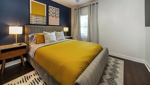 A bedroom with a bed, nightstands, a ceiling fan, and artwork on the wall. - Cozy Gem, Hot Tub,  close to downtown Berkley shops and restaurants (Berkley)