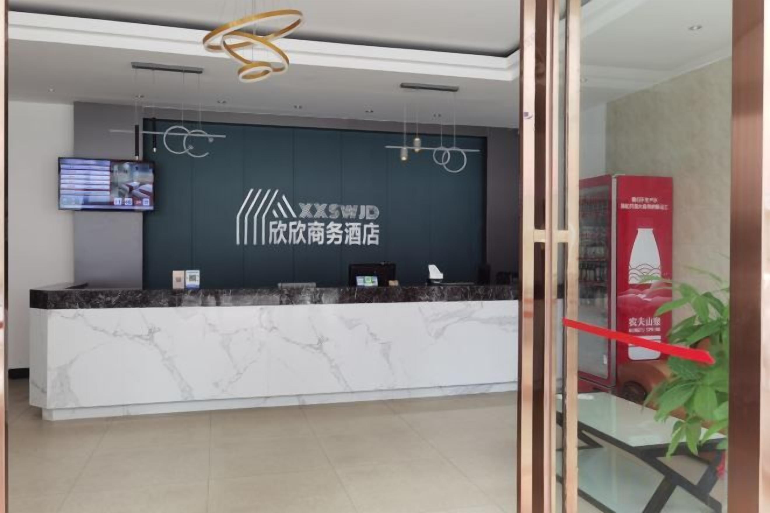 Una recepción con una pantalla digital, un logotipo y una barra de mostrador.