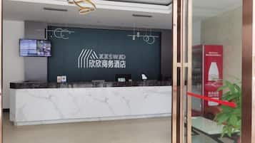 Una recepción con una pantalla digital, un logotipo y una barra de mostrador.