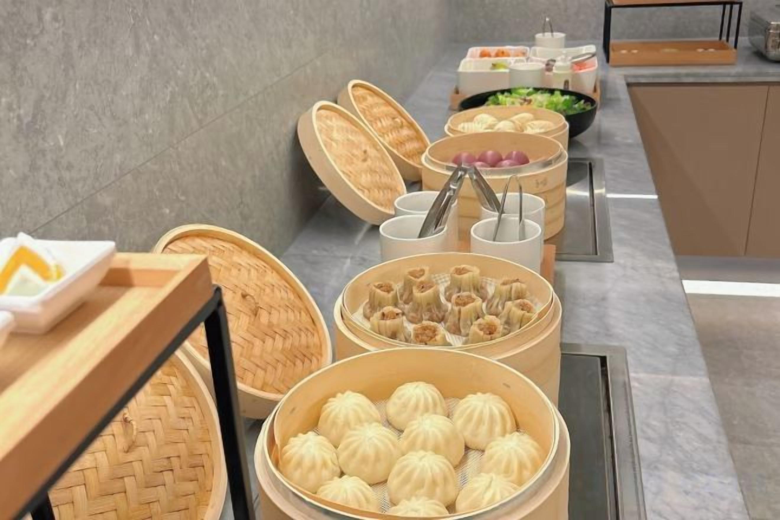 A buffet setup with various food items, including dumplings and other dishes, arranged on a counter.