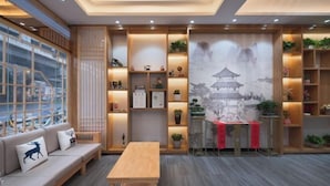 A modern interior with a wooden bench, a table, and shelves with decorative items. - Chenyue Hotel (Chengdu Southwest University of Finance and Economics Subway Station) (Chengdu)