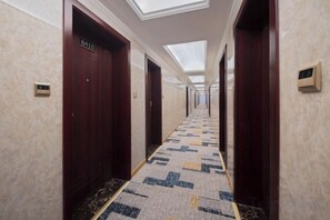 A hotel hallway with wooden doors, numbered room signs, and a patterned carpet. - Chenyue Hotel (Chengdu Southwest University of Finance and Economics Subway Station) (Chengdu)