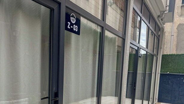 A modern building with large glass doors and a sign indicating room number 703. - Kalmuk Suite Hotel (Trabzon)