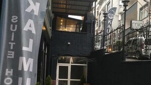 A hotel entrance with a banner reading "KUNUK HOTEL," a stone facade, and a gated entrance. - Kalmuk Suite Hotel (Trabzon)