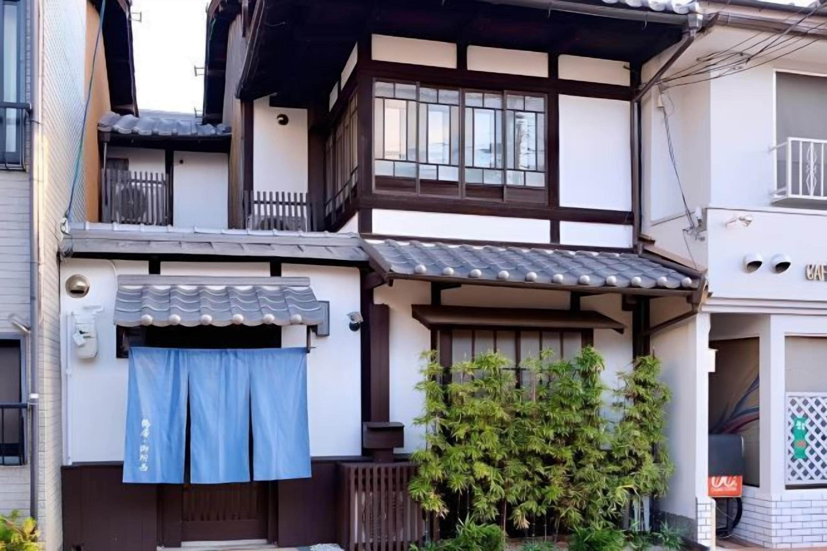 Un bâtiment de style japonais traditionnel, avec un toit recouvert de tuiles, des poutres en bois et un petit balcon.