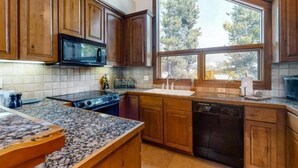 A kitchen with wooden cabinets, a microwave, stove, and a dishwasher. - Ski In, Ski Out 3 Bedroom Townhome at Snowflake Lift - Private Hot Tub (Breckenridge)