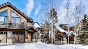 A large, multi-story lodge with a prominent balcony and stone facade, surrounded by snow-covered ground and trees. - Ski In, Ski Out 3 Bedroom Townhome at Snowflake Lift - Private Hot Tub (Breckenridge)