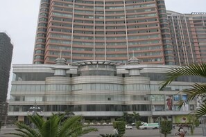 A multi-story hotel with a curved facade, large windows, and a central entrance.
