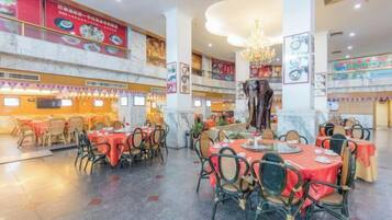 Ein Restaurant mit mehreren Tischen, Stühlen und einer Kronleuchter.