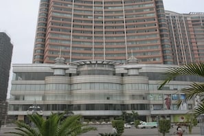 Un hotel de varios pisos con fachada curva, ventanas amplias y una entrada central.