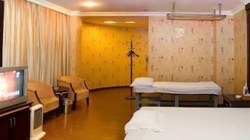 Relax in comfort with a large bed and a convenient television on a stand.
