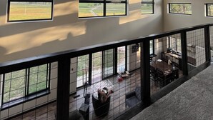 A spacious room with large windows and ceiling fans.