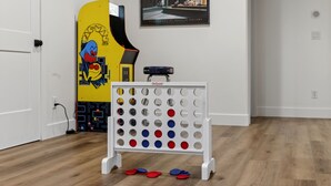 A room with a white door, a white stand with circular holes, and a colorful board with a cartoon character. - New Modern 5BR with AC - Walk to Targhee Shuttle (Driggs)
