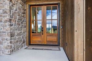 A stone wall, a wooden door with glass panels, and a doormat with 'Bargood Manor' text. - New Modern 5BR with AC - Walk to Targhee Shuttle (Driggs)