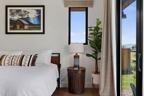 Une chambre à coucher avec un lit, une lampe, une fenêtre et une plante.