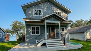 A two-story house with a front porch, a staircase leading to the entrance, and a well-maintained lawn. - Escape to a lakeside cabin with stunning panoramic views of Ottertail Lake
 (Ottertail)