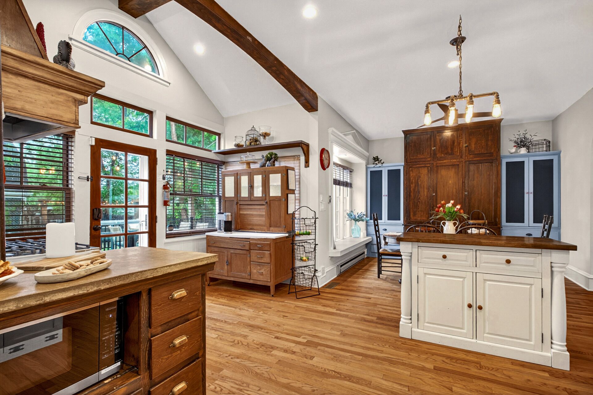 A spacious kitchen with wooden cabinets, a built-in oven, and a large island with a sink.