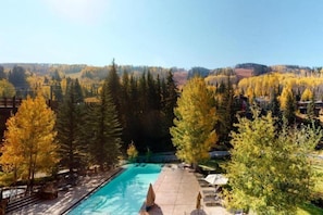 A swimming pool with a view of a forested landscape. - Ski In, Ski Out 1 Bedroom Condo at the Eagle Bahn Gondola (Vail)