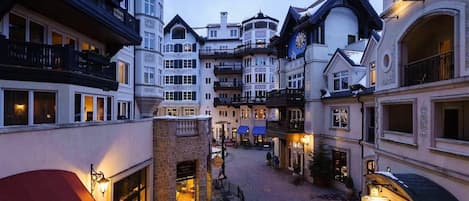 Un edificio de varios pisos con balcones, un patio central y zonas de estar al aire libre.