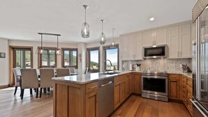 A modern kitchen with wooden cabinets, stainless steel appliances, and pendant lighting. - Beaver Creek Village Ski In, Ski Out 2 Bedroom Residence With Pool (Avon)
