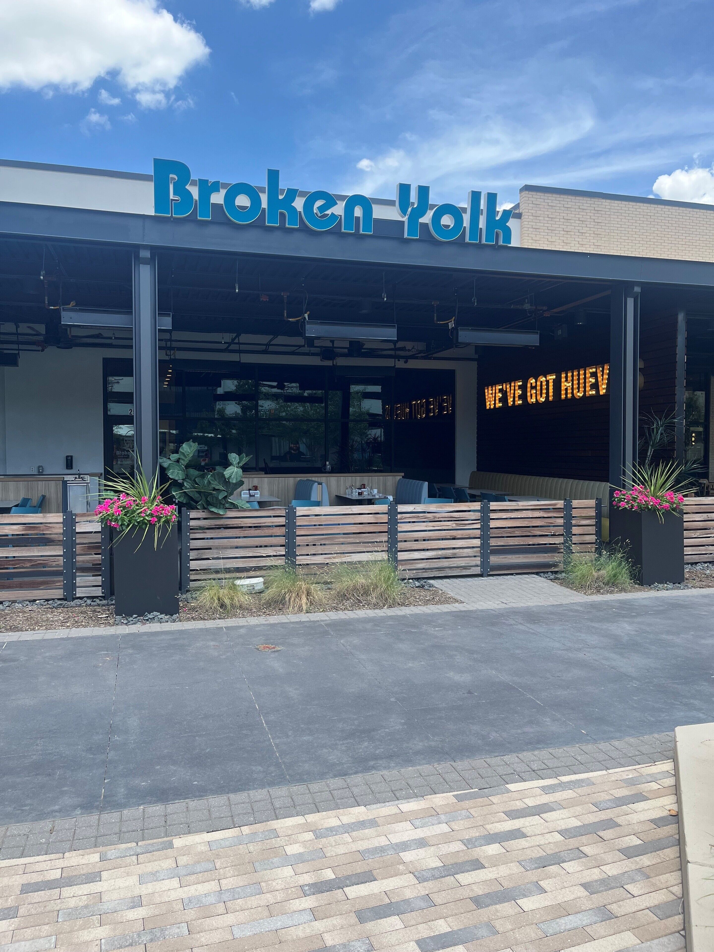 A restaurant named 'Broken Heart' with a sign that reads 'WE'VE GOT HUEV'.