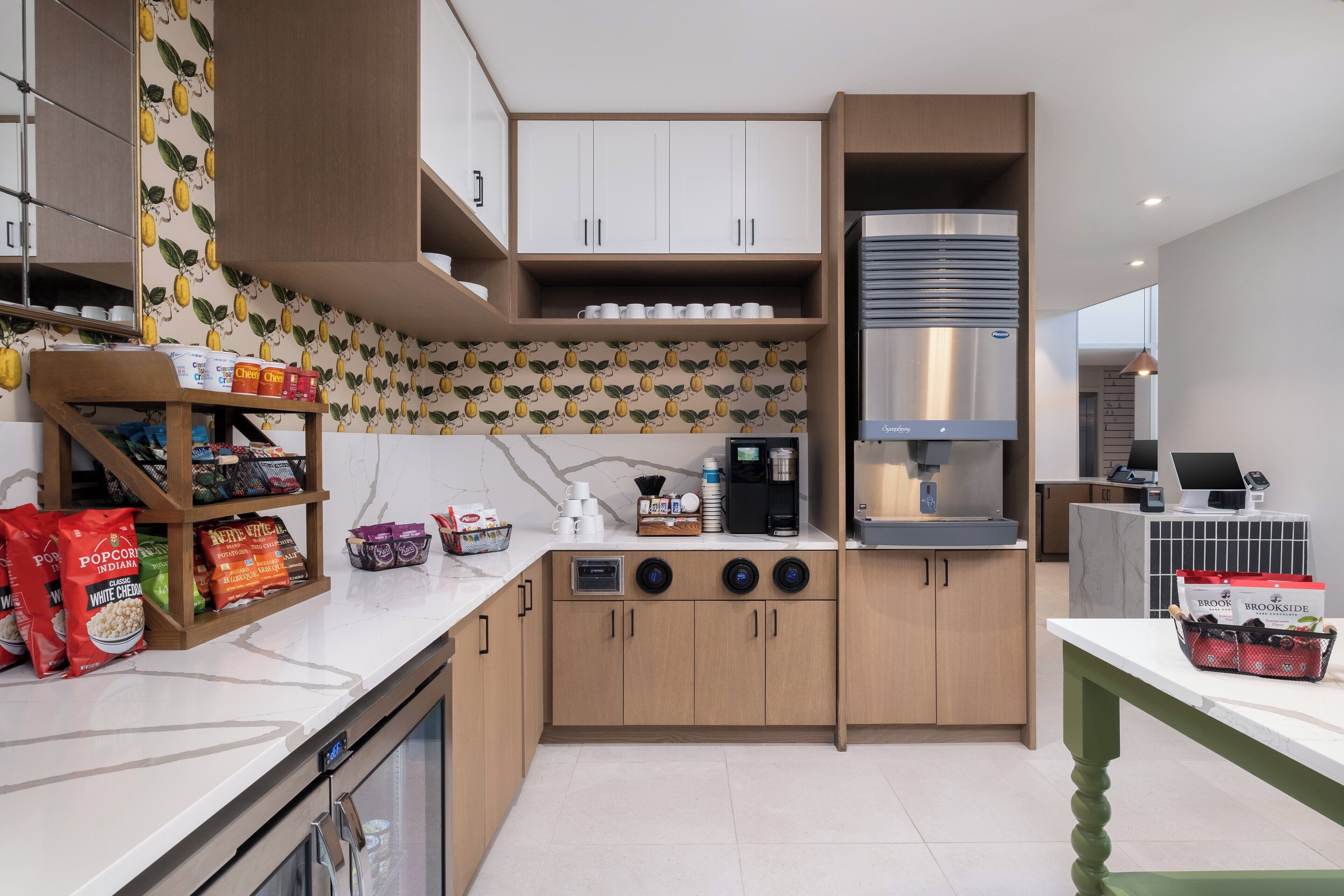 Een moderne keuken met houten kastjes, een roestvrijstalen afzuigkap en een marmeren aanrecht.
