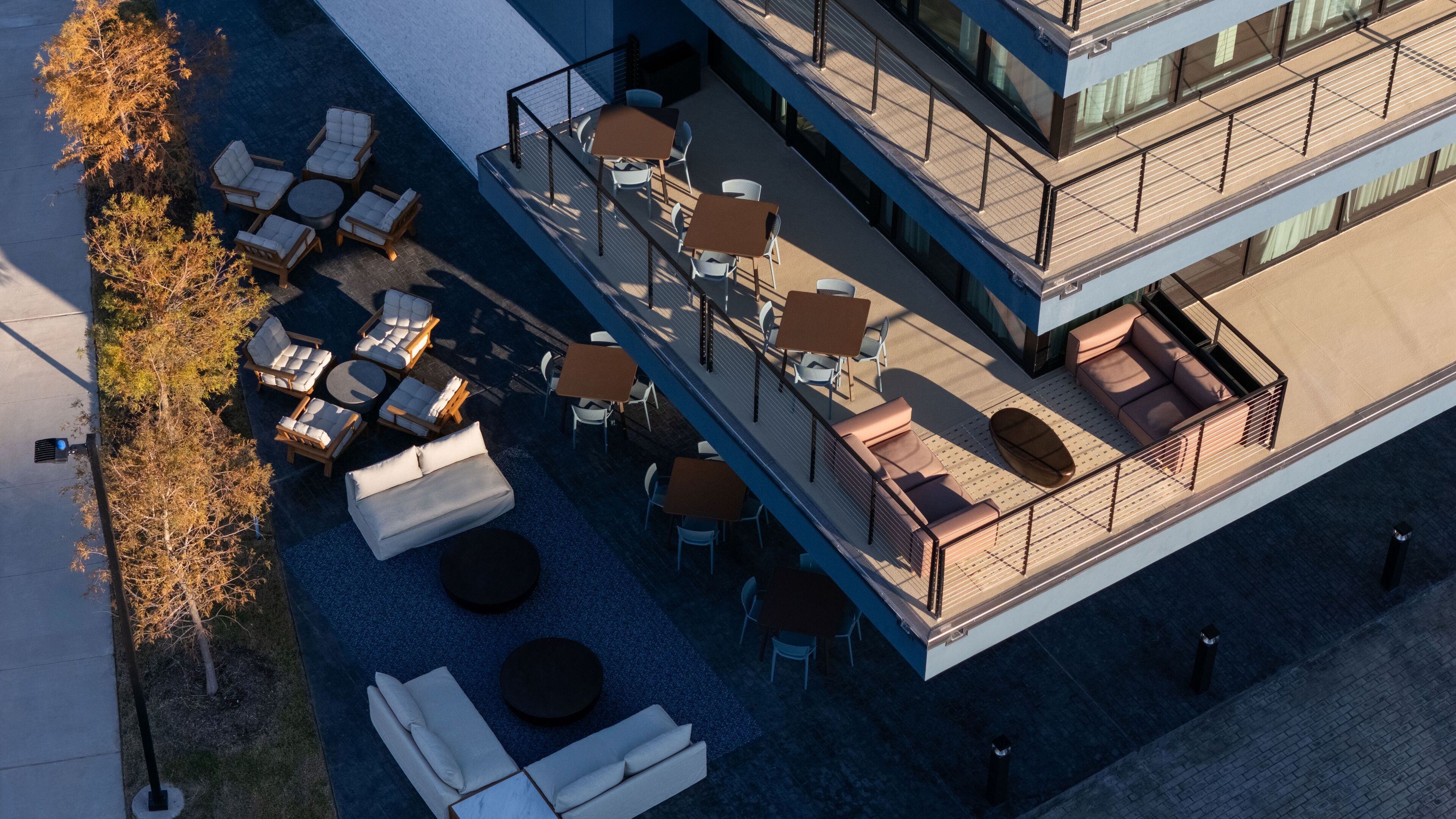 Vue aérienne d’une terrasse sur le toit, aménagée avec des meubles d’extérieur, notamment des canapés et des tables, ainsi qu’un espace piscine.