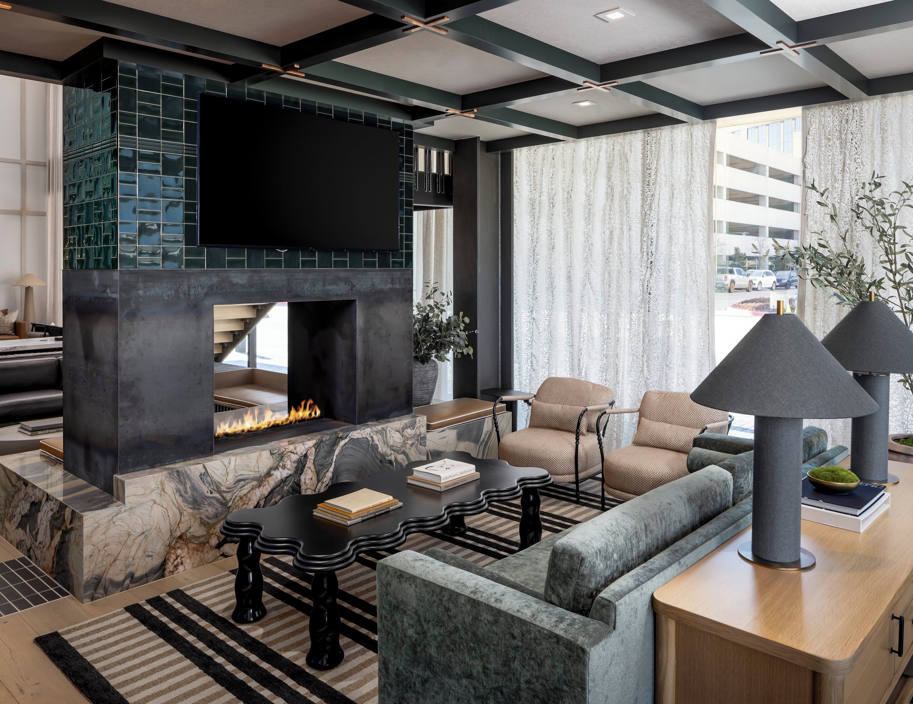 A modern living room with a fireplace, comfortable seating, and a flat-screen TV.