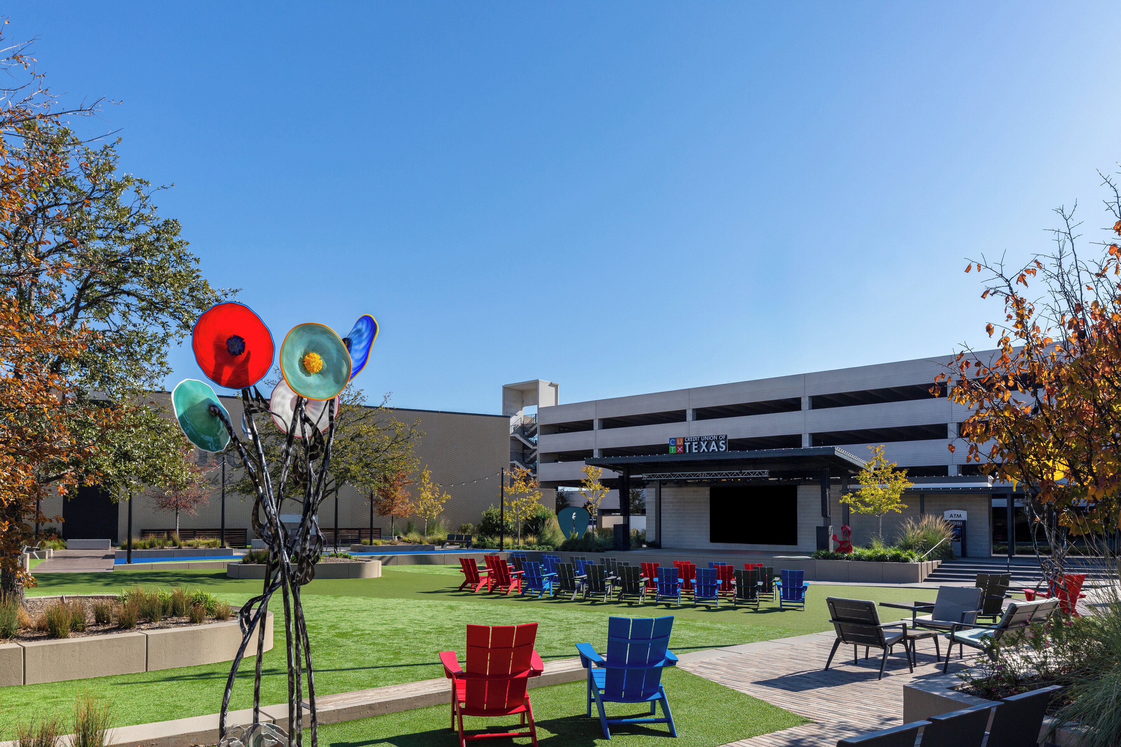 An outdoor seating area with chairs and a sculpture.