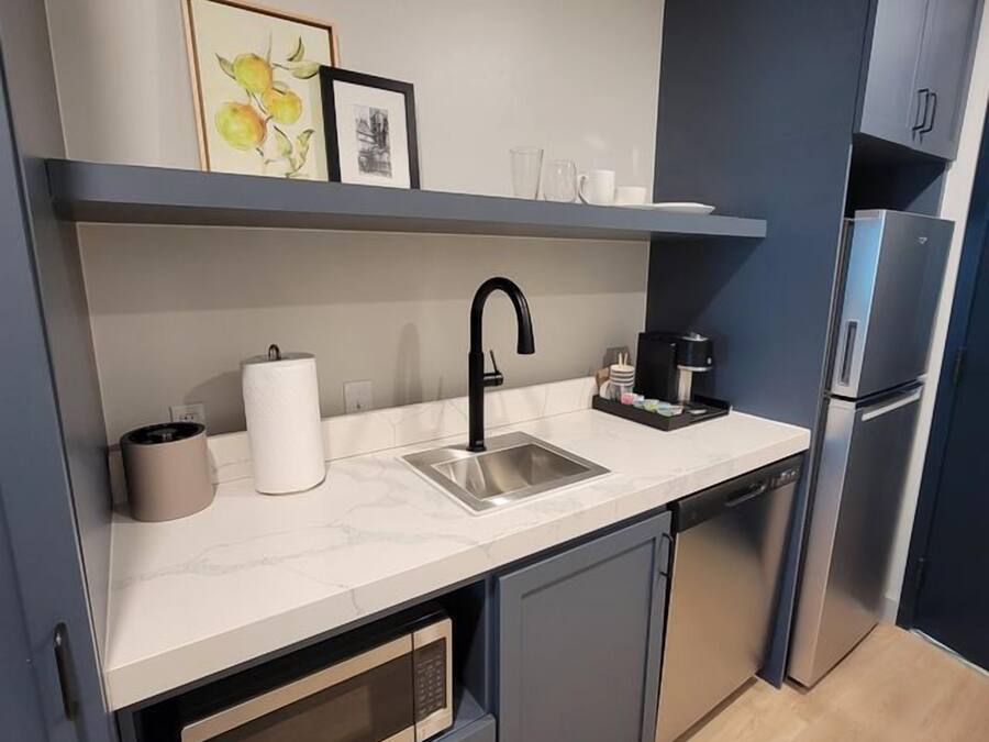 A modern kitchen with a sink, a coffee maker, and a microwave.