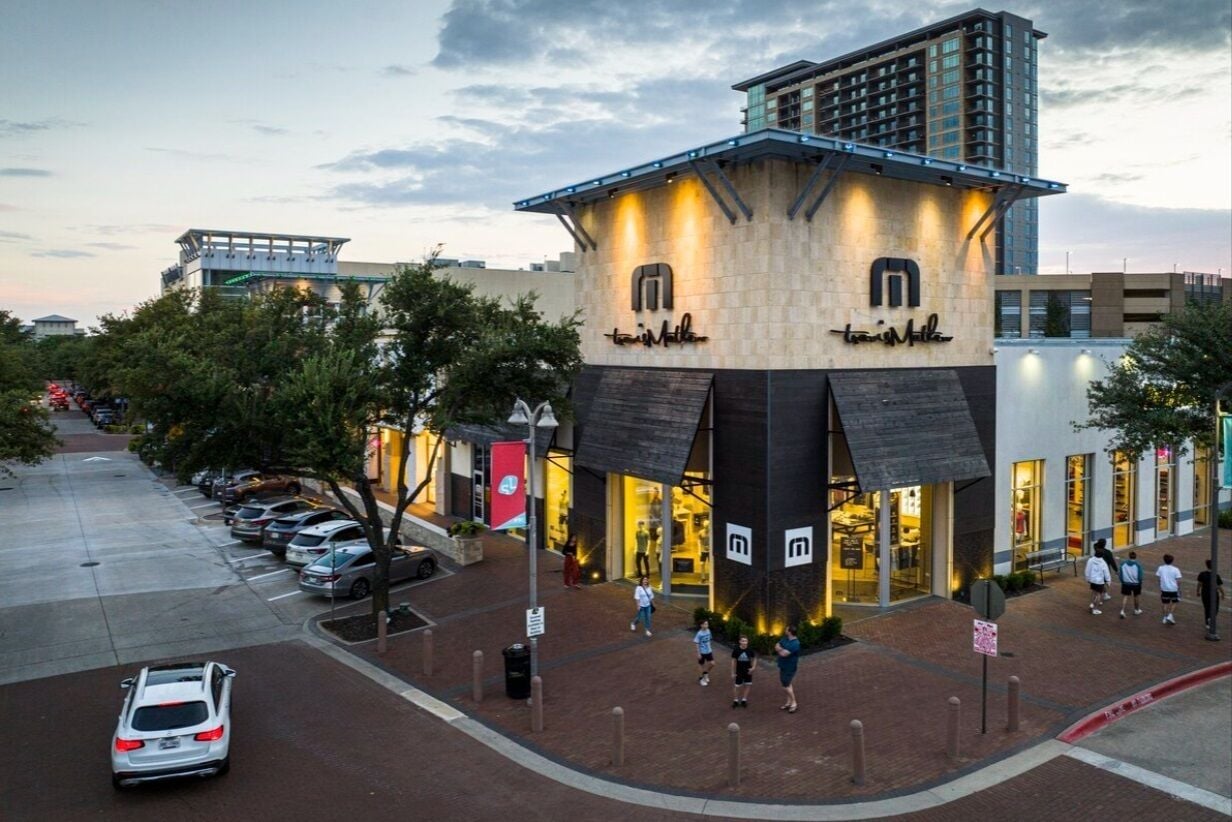 A modern building with a unique architectural design, featuring a prominent tower and a ground-level entrance.