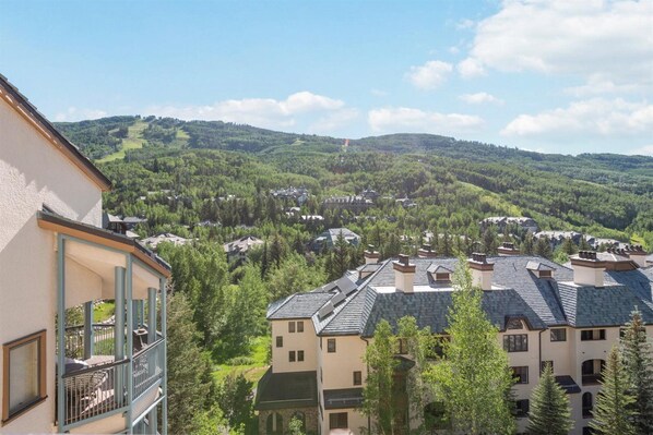 Ein Wohngebiet mit mehreren Gebäuden, darunter ein zweistöckiges Haus mit Balkon und ein Gebäude mit flachem Dach.