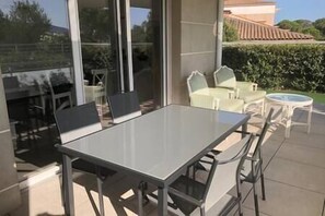 Enjoy al fresco dining with a glass-top table and comfortable seating, surrounded by beautiful views of the landscape.