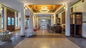 A spacious lobby with a central chandelier, a hanging swing, and a stone fountain. - Lanna Deer Chiang Mai (Hang Dong)