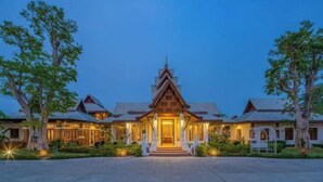 A traditional multi-story building with a central entrance, surrounded by trees. - Lanna Deer Chiang Mai (Hang Dong)