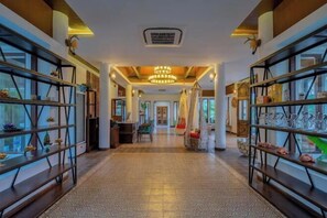 A hotel corridor with glass shelving on both sides, a central walkway, and a hanging chair. - Lanna Deer Chiang Mai (Hang Dong)