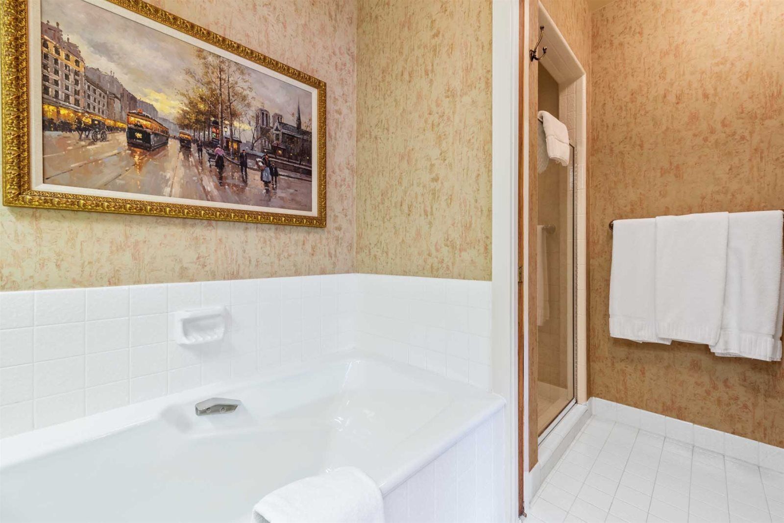 Un bagno con vasca, doccia e porta asciugamani.