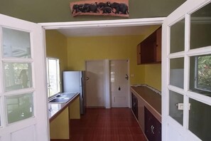 A compact kitchen with a refrigerator, sink, and cabinets. - Parichat house (Pak Chong)