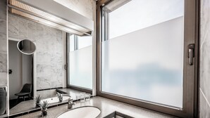 A modern bathroom with a large window, a sink, and a mirror. - Hotel Mirage Düsseldorf-Neuss (Neuss)