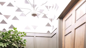 A hallway with a wooden door, a potted plant, and a patterned rug. - Our 2nd Studio at The Lofts in Hesperia.
 (Hesperia)