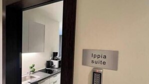 L’entrée d’une chambre d’hôtel, avec une pancarte indiquant « Suite Ippia ».