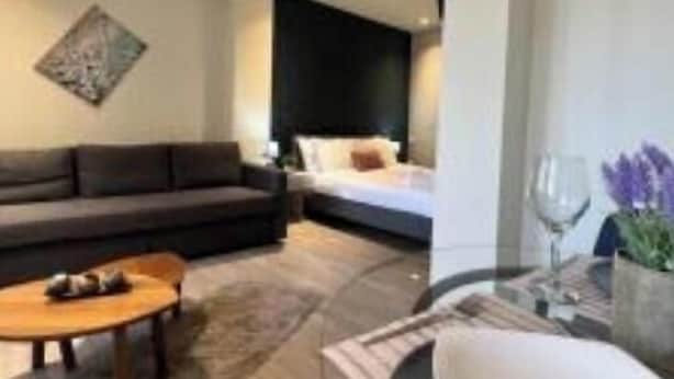 Un salon moderne comprenant un canapé, une table basse et un coin repas avec une table et des chaises.